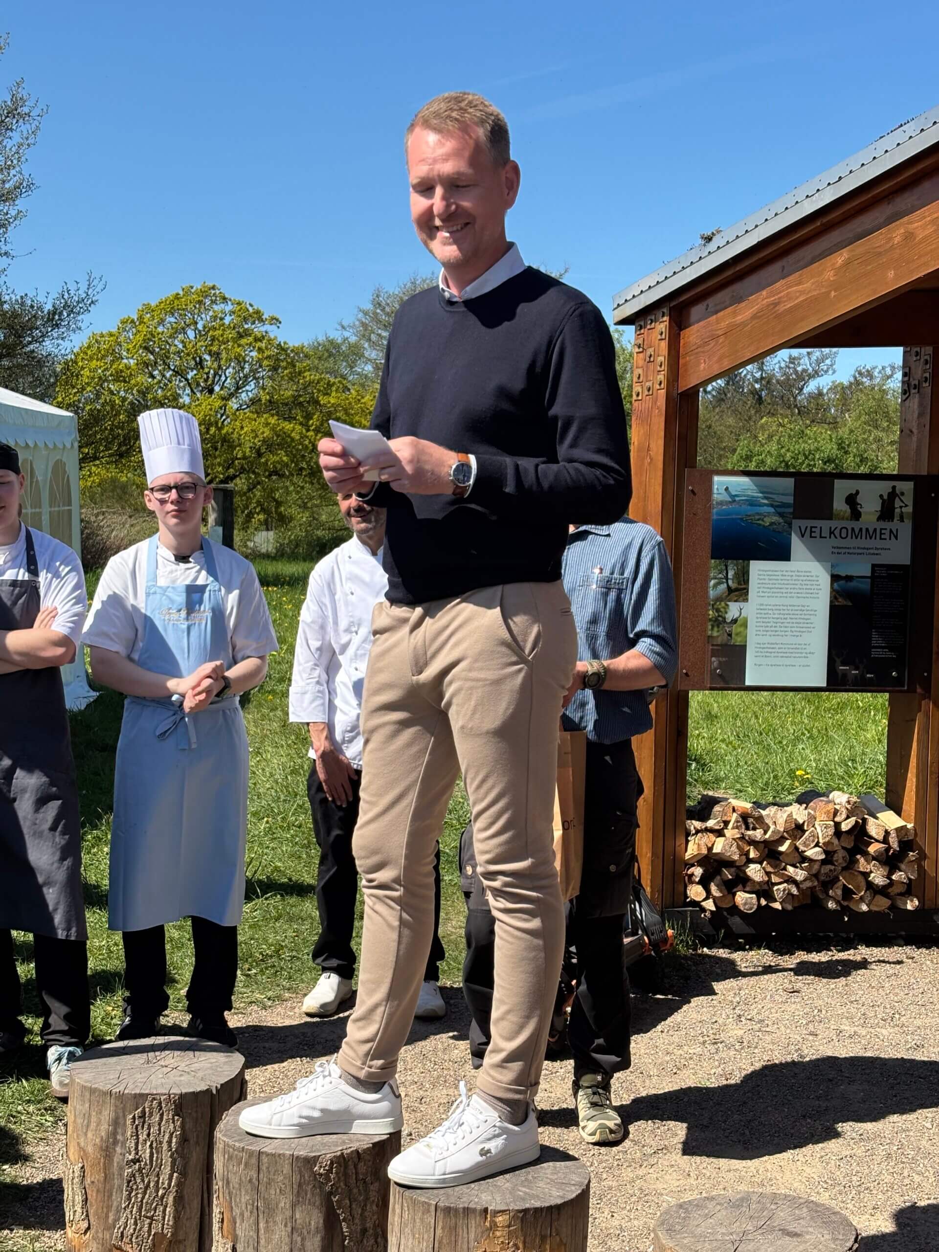 People standing outside. Some are wearing chef hats. Seemingly a price ceremony.